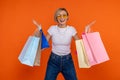 Extremely happy woman in white t shirt and jeans standing with shopping bags Royalty Free Stock Photo