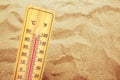 Extremely high temperatures, thermometer on warm desert sand Royalty Free Stock Photo