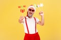 Extremely positive excited grey bearded adult man in red hat and pants with suspenders holding congratulations cards on sticks, Royalty Free Stock Photo