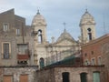 Extremity of a white baroque church with two bell towers with around old buildings to Catania in Sicily Italy.