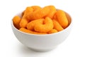 Extruded cheese puffs in a white ceramic bowl isolated on white