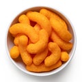 Extruded cheese puffs in a white ceramic bowl isolated on white. Top view