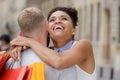 exuberant couple embracing woman holding shopping bags