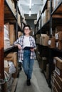 Exuberant female warehouse distribution worker holding a clipboard