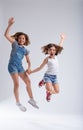 Exuberant young sisters jumping for joy