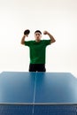 Exultant Asian man, table tennis champion demonstrated muscles in the end of match against white studio background