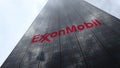 ExxonMobil logo on a skyscraper facade reflecting clouds, time lapse. Editorial 3D rendering