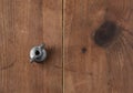 Eye bolt for attaching a handle for an old aluminum home manual meat grinder on a wooden table.