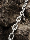 Eye bolt with iron chain anchored into sandstone rock. Twisted chain Royalty Free Stock Photo