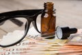 eye care concept - reading glasses, eye drops and money Royalty Free Stock Photo