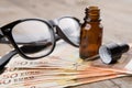 eye care concept - reading glasses, eye drops and money Royalty Free Stock Photo