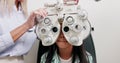 Eye care, vision and child in clinic, test and help of specialist, phoropter or refractor for girl. Healthcare