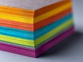 Vibrant stack of multi-colored textured paper sheets neatly arranged showing the variety of bright hues and material layers in Royalty Free Stock Photo