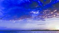 Blue coloured cumulus cloud, sunset seascape vista. Royalty Free Stock Photo