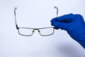 Eye doctor picks up the lenses to the patient. Astigmatic glasses for low vision. on white background in medical gloves