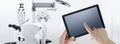 Eye examination test concept, hands touch screen of digital tablet, ophthalmology and optometry equipment on background