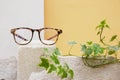 eye glasses on a concrete podium on a beige background, trend composition, stylish eye glasses on a beige background
