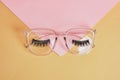 eye glasses on a concrete podium on a pink and beige background, trend composition, black stylish eye glasses,