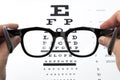 Eye glasses on eyesight test chart background. Royalty Free Stock Photo