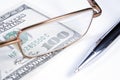 Eye-glasses, pen and banknote Royalty Free Stock Photo