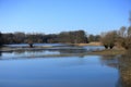Eye-level shot of a lake surrounded by trees under the clear blue sky Royalty Free Stock Photo