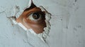 An eye looking through a torn hole in paper or wall. Royalty Free Stock Photo