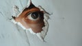 An eye looking through a torn hole in paper or wall. Royalty Free Stock Photo