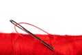 Eye of the needle with red polyester thread. Spool of red polyester sewing thread in the background. Selective focus. Bokeh Royalty Free Stock Photo