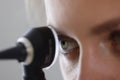 Eye of otorhinolaryngologist looking through otoscope in clinic