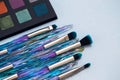 Cosmetics on plain background, brushes and eye-shadow palette Royalty Free Stock Photo