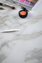Eye shadow palette, brushes, fake lashes, tweezers and artificial eyelid crease double tapes for eye makeup on marble beauty desk Royalty Free Stock Photo