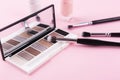 Eye shadow palette and makeup brushes on pastel pink background Royalty Free Stock Photo
