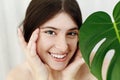 Eye Skin Care and Treatment. Portrait of beautiful young happy woman holding hands at eyes skin at green palm leaf. Girl enjoying Royalty Free Stock Photo