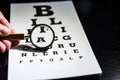 Eye test chart with a mgnifying glass, black background Royalty Free Stock Photo