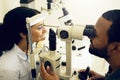 Eye test, machine and a woman with a doctor for optometry, vision problem and surgery on lens. Happy, clinic and a Royalty Free Stock Photo