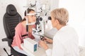 Eye test, optometrist and vision with a woman optician using an autorefractor during an exam with a patient. Eyewear Royalty Free Stock Photo