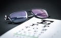 Eye test and sight exam concept. Glasses on letter chart.