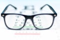 Eye vision test chart seen through eye glasses. Royalty Free Stock Photo