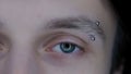 Eye of young guy with eyebrow piercing macro shot. Enlarged pupils, due to prolonged use of gadgets. Dry eye syndrome Royalty Free Stock Photo