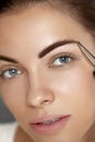 Eyebrow Correction. Closeup Of Beautiful Young Woman With Perfect Makeup And Long Lashes Plucking Eyebrows. Royalty Free Stock Photo