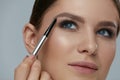 Eyebrow makeup. Beauty model shaping brows with brow pencil Royalty Free Stock Photo