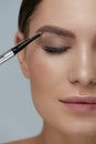 Eyebrow makeup. Beauty model shaping brows with brow pencil Royalty Free Stock Photo