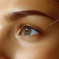 Eyebrow shaping procedure using thread, close-up of beautician\'s hands