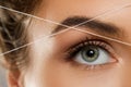 Eyebrow threading - epilation procedure for brow shape correction Royalty Free Stock Photo
