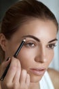 Eyebrows shaping. Beauty young woman with brow pencil. Royalty Free Stock Photo
