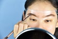 Eyebrows shaping makeup template, Asian women filling eyebrows to look thicker. Royalty Free Stock Photo