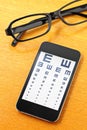 Eyechart on mobile with glasses Royalty Free Stock Photo