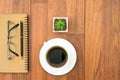 Eyeglasse and notepad with coffee cup on wood deck