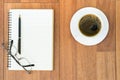 Eyeglasse and notepad with coffee cup on wood deck