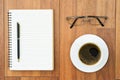 Eyeglasse and notepad with coffee cup on wood deck